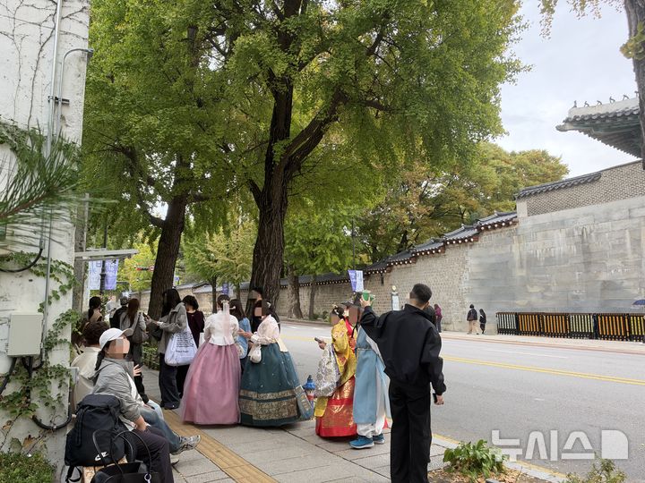 [서울=뉴시스] 이수진·정승혜 인턴기자=19일 서울 종로구 효자로 은행나무길에서 시민들이 사진을 찍고 있다.2026.10.19.