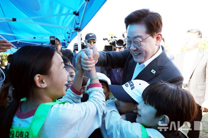 [익산=뉴시스] 김진아 기자 = 이재명 대통령이 22일 전북 익산 왕궁초등학교에서 열린 가을 행복학교 체육한마당에서 학생들과 인사를 하고 있다. 2026.10.22. bluesoda@newsis.com