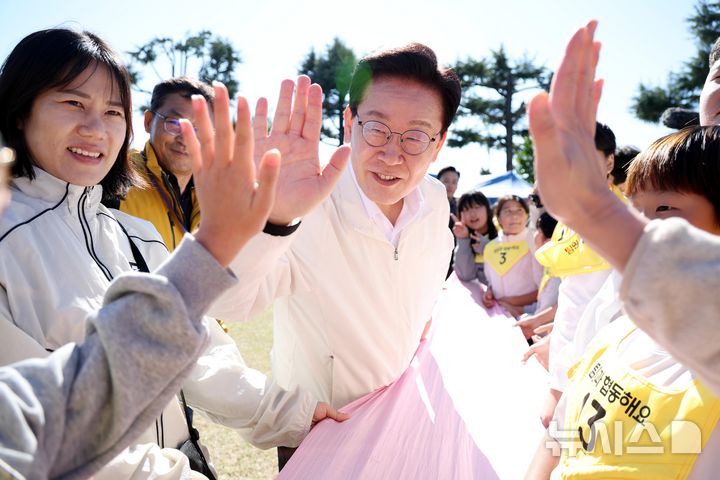 [익산=뉴시스] 김진아 기자 = 이재명 대통령이 22일 전북 익산 왕궁초등학교에서 열린 가을 행복학교 체육한마당에서 학생들과 하이파이브를 하고 있다. 2026.10.22. bluesoda@newsis.com