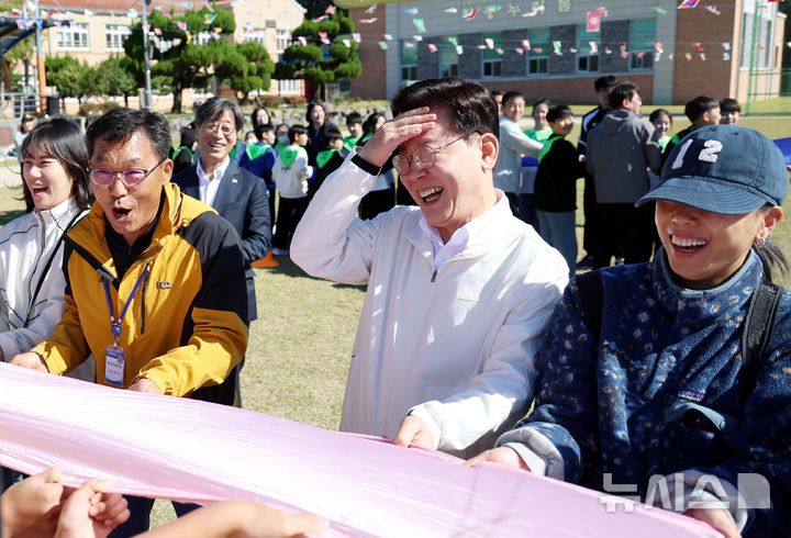 [익산=뉴시스] 김진아 기자 = 이재명 대통령이 22일 전북 익산 왕궁초등학교에서 열린 가을 행복학교 체육한마당에서 교사, 학부모, 학생들과 '짐볼 이동하기'를 하고 있다. 2026.10.22. bluesoda@newsis.com