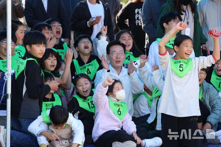 [익산=뉴시스] 김진아 기자 = 이재명 대통령이 22일 전북 익산 왕궁초등학교에서 열린 가을 행복학교 체육한마당에서 학생들과 함께 응원을 하고 있다. 2026.10.22. bluesoda@newsis.com