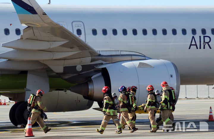 [부산=뉴시스] 하경민 기자 = 2026년 김해공항 항공기 사고수습 종합훈련이 열린 22일 부산 강서구 김해국제공항에서 소방대원 등이 항공기 활주로 이탈 사고를 가정, 부상자를 이송하고 있다. 이날 훈련에는 한국공항공사와 공군, 소방, 경찰, 남해지방해양경찰청, 항공사 등 30개 기관의 인원 300여 명이 참가했다. 2026.10.22. yulnetphoto@newsis.com