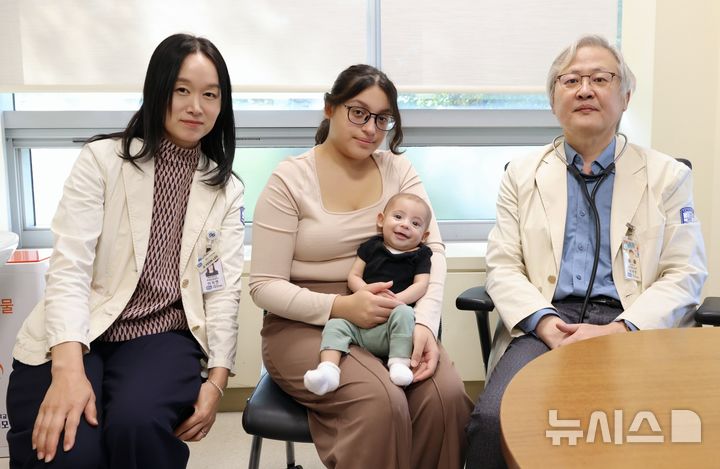 [서울=뉴시스] 심부전 증상으로 심장 수술을 받은 미군 가족 신생아와 이지연 국제진료센터장 교수(좌측), 소아청소년 심장병 클리닉을 이끌고 있는 이재영 교수(우측). (사진= 서울성모병원 제공)