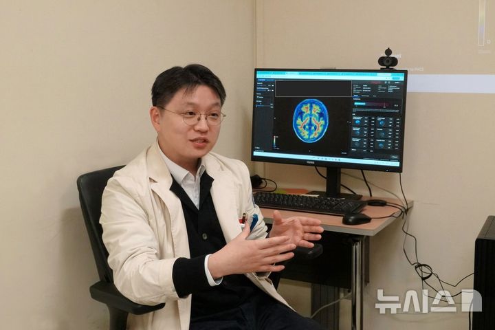 [서울=뉴시스] 하승균 가톨릭대학교 서울성모병원 핵의학과 교수가 뉴시스 기자에게 아밀로이드 PET분석 인공지능(AI) 솔루션을 이용해 환자의 뇌 영상을 정량적으로 분석하는 진단 과정을 설명하고 있다. (사진= 서울성모병원 제공)