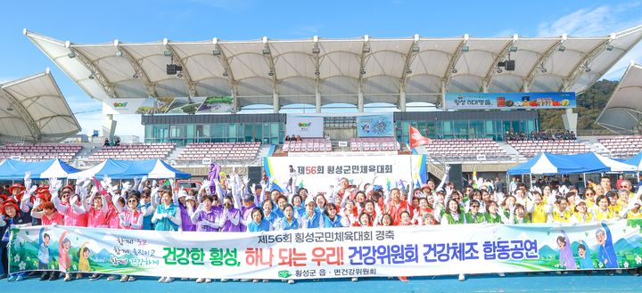 [횡성=뉴시스] 횡성군 9개 읍면 건강위원회 위원들이 제56회 횡성군민 체육대회 식전 행사에서 건강 체조 공연을 마친 뒤 기념사진을 촬영하고 있다. (사진=횡성군 제공) 2026.10.23. photo@newsis.com *재판매 및 DB 금지