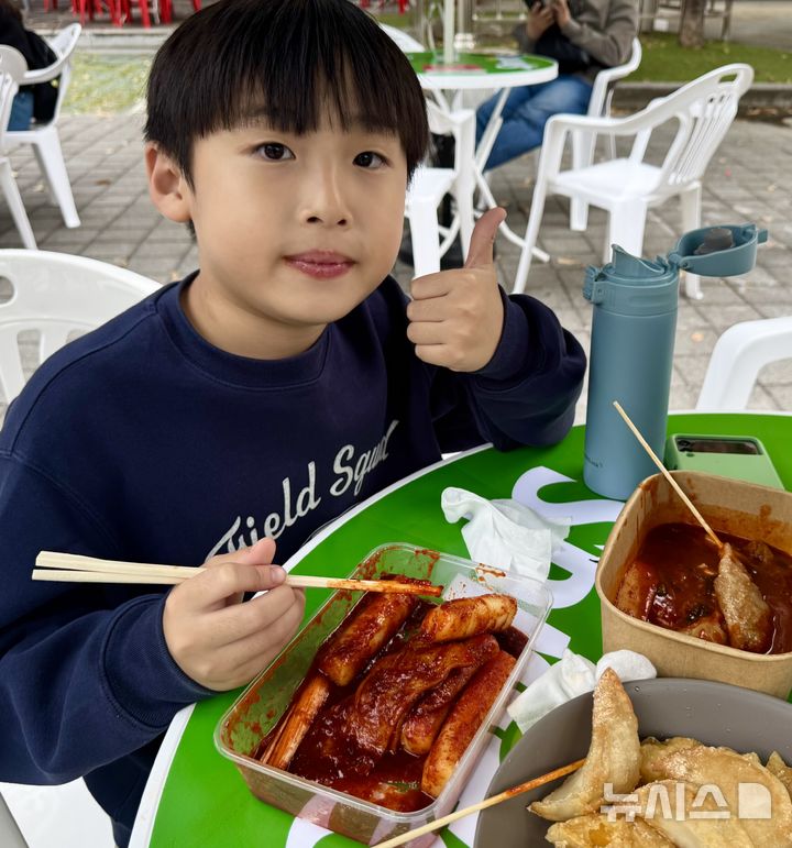 [대구=뉴시스] 정재익 기자 = 23일 대구 북구 고성동 iM뱅크PARK 일대에서 열린 '제6회 떡볶이 페스티벌'에서 한 어린이가 떡볶이를 먹으며 엄지손가락을 들어 보이고 있다. 2026.10.23. jjikk@newsis.com