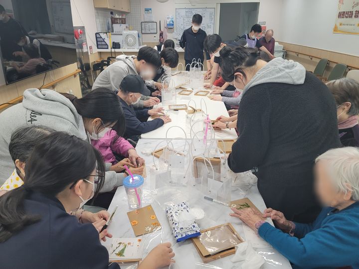 [과천=뉴시스] 박종대 기자 = 23일 경기 과천시립요양원에서 과천중앙고 학생들과 어르신들이 꽃과 나뭇잎을 활용해 액자를 꾸미고 있다. 2026.10.23. pjd@newsis.com *재판매 및 DB 금지