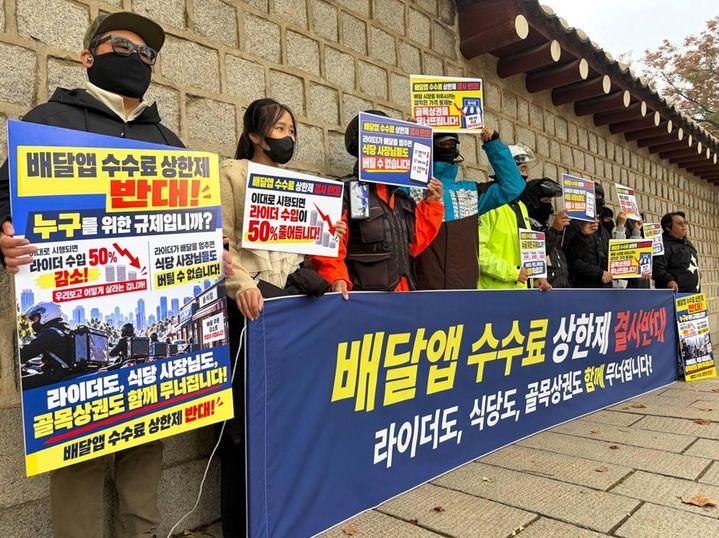 지난 21일 서울 종로구 청와대 앞에서 라이더들이 배달앱 수수료 상한제에 반대하며 피켓과 현수막을 들고 있다. *재판매 및 DB 금지