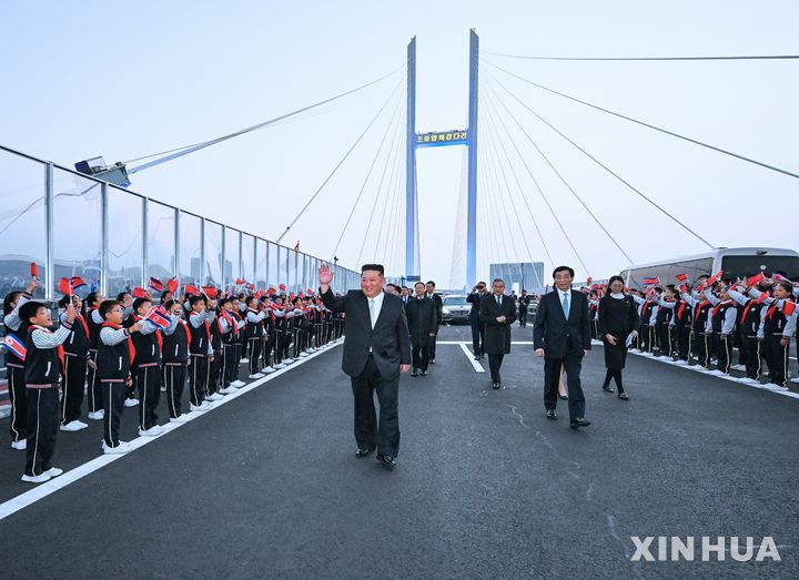 [단둥=신화/뉴시스] 김정은 북한 국무위원장이 24일(현지 시간) 중국 랴오닝성 단둥 방문을 마친 뒤 서열 4위 왕후닝 전국인민정치협상회의(정협) 주석의 배웅을 받으며 신압록강대교에서 환송객들에게 인사하고 있다. 김 위원장은 이 다리를 통해 북한으로 돌아갔다. 2026.10.25.