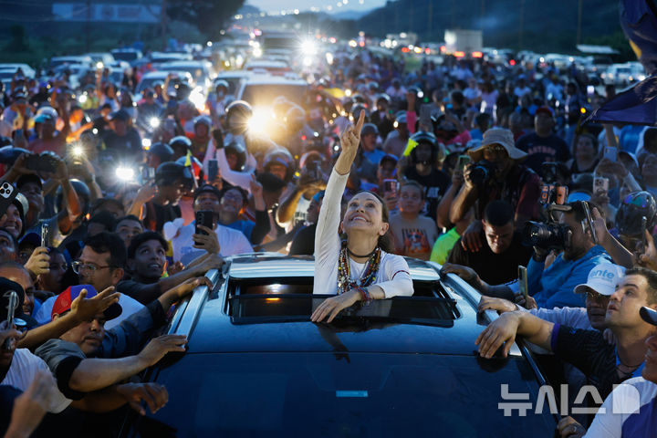 [발렌시아=AP/뉴시스] 25일(현지 시간) 베네수엘라 발렌시아에서 노벨평화상 수상자인 야권 지도자 마리아 코리나 마차도가 10개월간의 망명 생활을 마치고 귀국한 뒤 지지자들의 환영을 받고 있다. 마차도는 2027년 7월까지 대선 실시를 요구하고, 전국 23개 주를 순회하며 정치 조직을 재건하겠다고 밝혔다. 그는 가상 대선에서 델시 로드리게스 임시 대통령을 크게 앞선 것으로도 알려졌다. 2026.10.26.