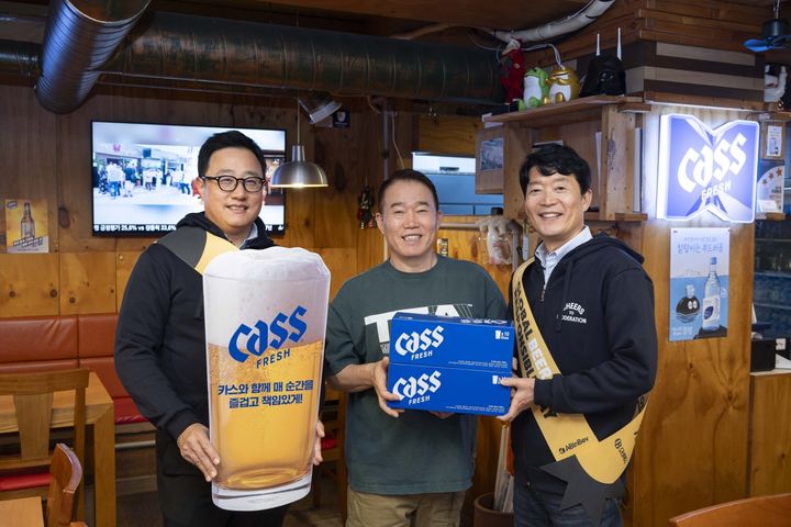 [서울=뉴시스] '글로벌 건전음주의 날'을 맞아 구자범 오비맥주 수석 부사장(왼쪽)과 김병훈 오비맥주 영업 부사장(오른쪽)이 점주에게 책임음주 문구가 담긴 맥주잔을 전달하고 기념사진을 찍고 있다. (사진=오비맥주 제공) *재판매 및 DB 금지