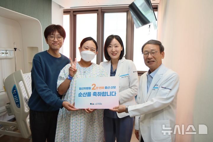 [서울=뉴시스] 우측부터 송재만 일산차병원 병원장과 주치의 홍기림 교수가 2만 번째 출산 산모와 가족에게 축하 선물을 전달하고 있다. (사진= 일산차병원 제공)