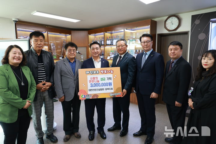 [영동=뉴시스] 대한전문건설협회 충북도회 류근형(사진 오른쪽 네번째) 회장과 장시영 영동군운영위원장 등 협회 임원들이 정영철(사진 왼쪽 네번째) 충북 영동군수에게 겨울나기 사랑의 연탄나눔 성금 300만원을 기탁하고 있다. (사진=영동군 제공) 2026.10.26. photo@newsis.com