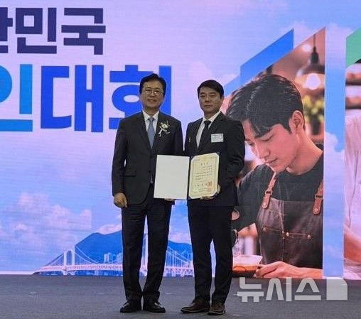 [부산=뉴시스]경상남도소상공인연합회 신영철(오른쪽) 회장이 부산광역시 벡스코에서 열린 중소벤처기업부 주최 '2026년 대한민국 소상공인대회' 유공자 시상식에서 국무총리 표창을 받은 후 기념촬영하고 있다.(사진=경남소상공인연합회 제공) 2026.10.26. photo@newsis.com
