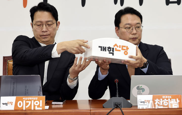 [서울=뉴시스] 최진석 기자 = 이기인(왼쪽) 개혁신당 비상대책위원장과 천하람 원내대표가 26일 여의도 국회에서 열린 비상대책위원회의에서 마이크통을 옮기고 있다. 2026.10.26. myjs@newsis.com