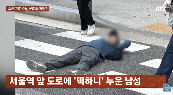 [서울=뉴시스] 서울역 앞 도로에 한 남성이 대자로 누워 있는 모습이 공개됐다. (사진 출처=JTBC '사건반장' 캡처)