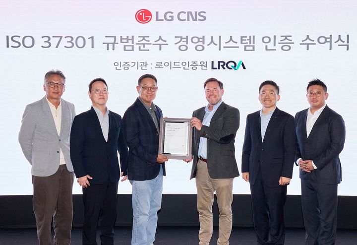 LG CNS 현신균 사장(왼쪽에서 세번째)과 로이드인증원 글로벌커머셜어드바이저 스튜어트 켈리(오른쪽에서 세번째) 및 관계자들이 인증 수여식에서 사진 촬영하는 모습 (사진=LG CNS 제공) *재판매 및 DB 금지