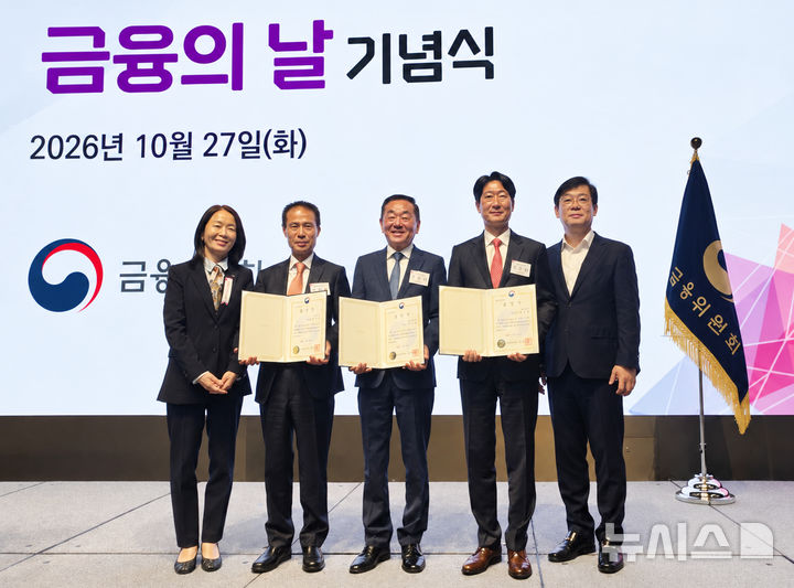 [서울=뉴시스]BNK경남은행 최명희(왼쪽서 첫 번째) 개인고객그룹장이 27일 서울 중구 웨스틴조선 호텔에서 열린 금융위원회 주관 '제11회 금융의 날 기념식'에서 대통령 표창 및 금융위원장 표창을 받은 거래 고객들과 기념촬영하고 있다.(사진=BNK경남은행 제공) 2026.10.27. photo@newsis.com