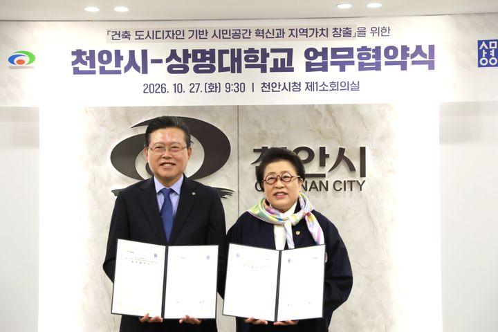 [천안=뉴시스] 27일 천안시청 소회의실에서 열린 ‘도시디자인 기반 시민공간 혁신 업무협약식’에서 장기수 천안시장과 상명대학교 김종희 총장이 협약서를 들고 기념촬영을 하고 있다. (사진=천안시 제공) 2026.10.27 photo@newsis.com *재판매 및 DB 금지