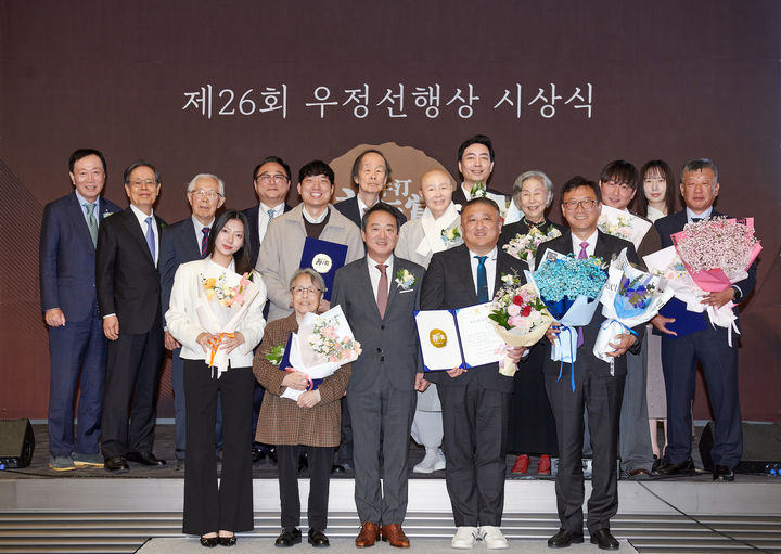 [서울=뉴시스] 코오롱그룹 오운문화재단이 27일 서울 마곡 코오롱원앤온리타워에서 제26회 우정선행상 시상식을 개최했다. 사진은 이웅열 재단 이사장(아랫줄 가운데)과 수상자, 심사위원들이 기념촬영을 하는 모습. (사진=코오롱그룹 제공) 2026.10.27 photo@newsis.com *재판매 및 DB 금지