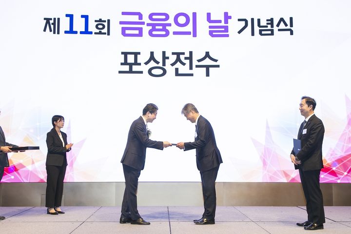 27일 오전 열린 제11회 금융의 날 기념식에서 이억원 금융위원회 위원장(가운데 왼쪽)이 케이뱅크 최우형 은행장(가운데 오른쪽)에게 포용금융부문 금융위원장상을 수여하고 있다. (사진=케이뱅크 제공) *재판매 및 DB 금지