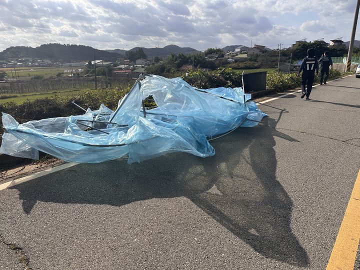 [무안=뉴시스] 27일 오후 2시25분께 전남광주 무안군 일로읍 한 도로에 비닐하우스가 날아와 소방당국이 안전조치를 하고 있다. (사진 = 전남광주통합소방본부 제공) 2026.10.27. photo@newsis.com *재판매 및 DB 금지