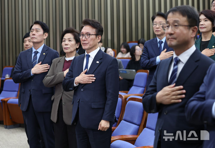 [서울=뉴시스] 김근수 기자 = 김민석 더불어민주당 대표를 비롯한 소속 의원들이 27일 오후 서울 여의도 국회에서 열린 의원총회에서 국민의례를 하고 있다. 2026.10.27. ks@newsis.com