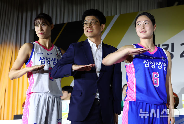 [서울=뉴시스] 전신 기자 = 하상윤 삼성생명 감독과 김아름, 이해란(왼쪽)이 27일 서울 강남구 호텔리베라 청담에서 열린 KB스타뱅킹 2026-2027 여자프로농구 개막 미디어데이에서 유니폼을 입고 기념촬영하고 있다. 2026.10.27. photo1006@newsis.com