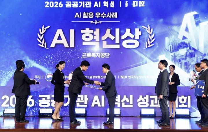 [울산=뉴시스] 근로복지공단 성덕환 산재보상이사(오른쪽)가 28일 서울 상암동 누리꿈스퀘어에서 열린 ‘2026 공공기관 AI 혁신 성과대회’에서 산재 요양기간 심사에 AI를 활용한 성과를 인정받아 AI 혁신상을 수상하고 있다. (사진=근로복지공단 제공) photo@newsis.com *재판매 및 DB 금지