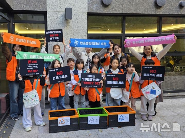 [수원=뉴시스] 수원시다함께돌봄센터 14호점 아동과 학부모, 교사 등이 플로깅 활동을 마친 뒤 기념촬영을 하고 있다. (사진=수원시다함께돌봄센터 14호점 제공) 2026.10.28.photo@newsis.com 