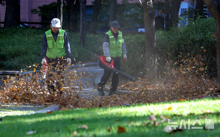 [대구=뉴시스] 이무열 기자 = 기온이 큰 폭으로 떨어지고 바람이 강하게 부는 28일 대구 달서구 월성공원에서 공원관리자들이 전동 송풍기를 이용해 낙엽을 청소하고 있다. 2026.10.28. lmy@newsis.com