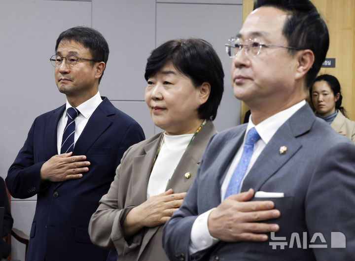 [서울=뉴시스] 최진석 기자 = 한병도(왼쪽부터) 더불어민주당 원내대표와 서영교, 박성준 의원이 28일 여의도 국회 의원회관에서 열린 윤석열 정권 정치검찰 조작기소 국조특위 사례보고회에서 국기에 경례하고 있다. 2026.10.28. myjs@newsis.com