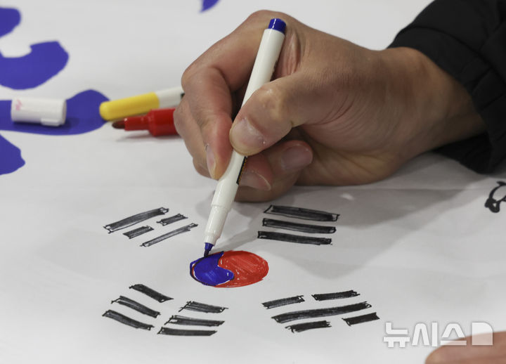 [울릉=뉴시스] 김근수 기자 = 29일 경북 울릉도로 향하는 여객선에서 ‘2026 독도탐방’에 참가한 참가자들이 독도 대형 퍼즐 현수막에 태극기를 그리고 있다.&nbsp; 한국해양재단(이사장 김양수)과 뉴시스(사장 염영남)는 독도의 가치를 알리고 해양영토에 대한 국민적 관심과 수호 의지를 높이기 위해 ‘2026 독도탐방’을 진행한다. 2026.10.29. ks@newsis.com