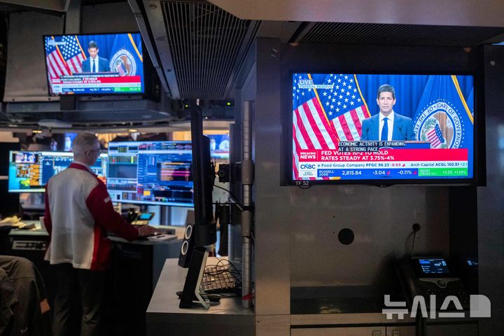 [뉴욕=AP/뉴시스] 28일(현지 시간) 미국 뉴욕증권거래소(NYSE) 거래장 내 스크린에 케빈 워시 연방준비제도(Fed·연준) 의장의 기자회견 모습이 나오고 있다. 2026.10.29.