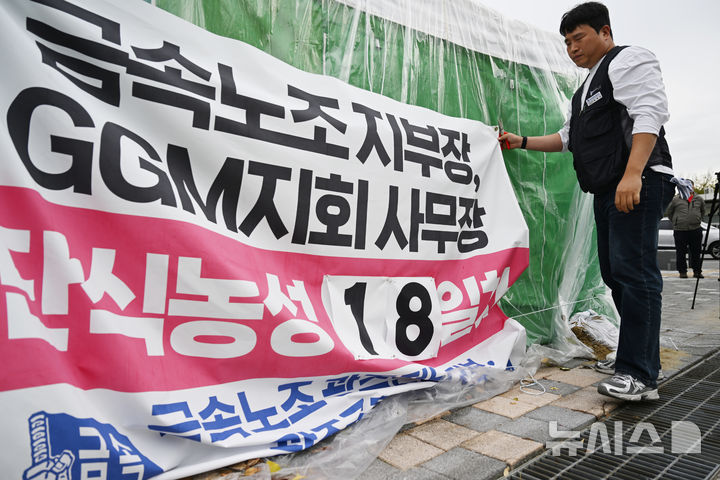 [전남광주=뉴시스] 이현행 기자 = 29일 오전 전남광주통합특별시 광주청사 앞에서 민주노총 금속노조 광주전남지부와 광주글로벌모터스(GGM) 지회가 사측과의 단체교섭 잠정합의에 따라 18일간 이어오던 단식농성을 철회, 현수막을 철거하고 있다. 2026.10.29. lhh@newsis.com