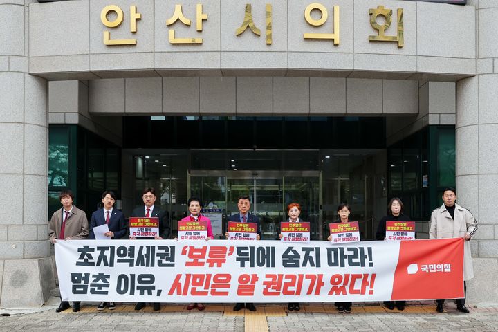 [안산=뉴시스] 경기 안산시의회 국민의힘 의원들이 29일 안산시의회 앞에서 더불어민주당의 '초지역세권 도시개발사업 출자동의안' 보류 처리에 항의하며 보류 이유를 설명하라며 규탄하고 있다. (사진=안산시의회 국민의힘 제공) 2026.10.29. photo@newsis.com *재판매 및 DB 금지