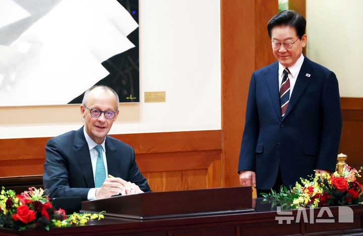 [서울=뉴시스] 김진아 기자 = 이재명 대통령이 29일 청와대에서 프리드리히 메르츠 독일 총리의 방명록 작성 모습을 지켜보고 있다. 2026.10.29. bluesoda@newsis.com