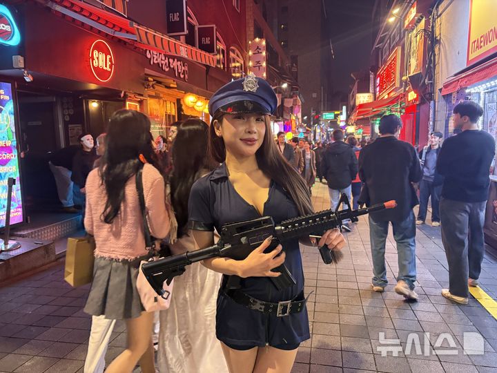 [서울=뉴시스] 신유림 기자 = 핼러윈을 하루 앞둔 30일 오후 서울 용산구 이태원 세계음식문화거리에서 경찰 복장을 한 시민이 장난감 총을 들고 포즈를 취하고 있다. 2026.10.30. spicy@newsis.com