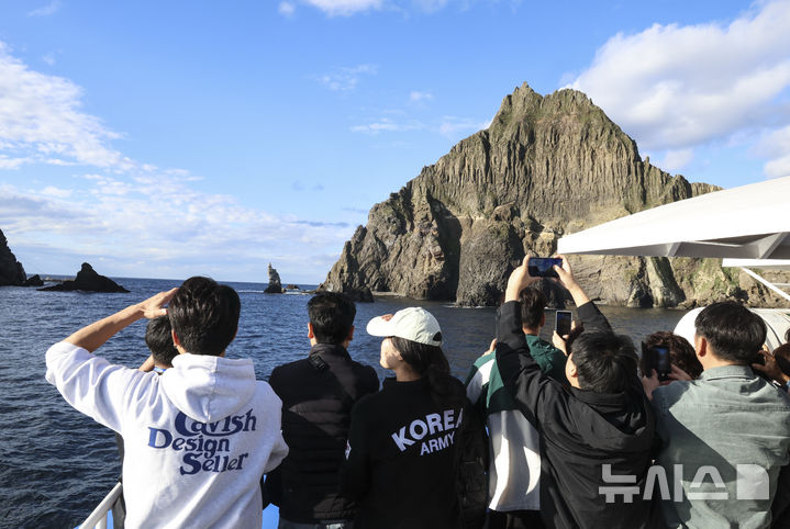 [독도=뉴시스] 김근수 기자 = 30일 오전 경북 울릉군 독도 해상에서 ‘2026 독도탐방’ 참가자들이 독도(동도와 서도)를 배경으로 기념촬영을 하고 있다. 이날 ‘2026 독도탐방’ 참가자들은 독도 연안에 높은 너울파도로 접안이 불가해 입도에 실패했다. 한국해양재단(이사장 김양수)과 뉴시스(사장 염영남)는 독도의 가치를 알리고 해양영토에 대한 국민적 관심과 수호 의지를 높이기 위해 ‘2026 독도탐방’을 진행한다. 2026.10.30. ks@newsis.com