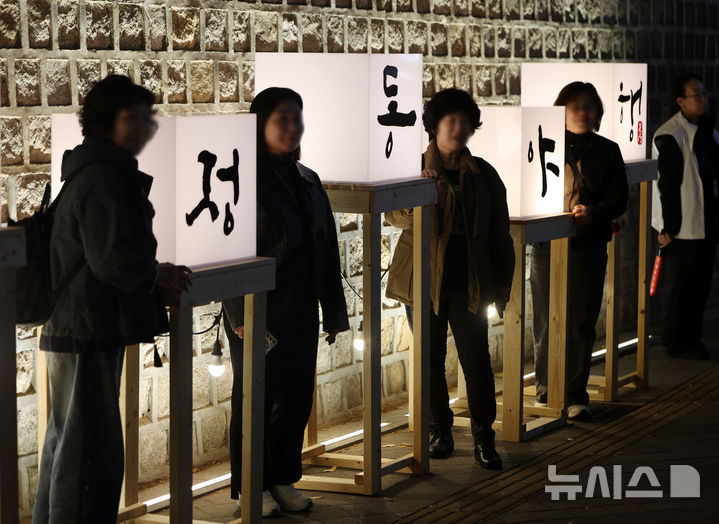 [서울=뉴시스] 김명년 기자 = 30일 오후 서울 중구 덕수궁 돌담길에서 열린 '2026 정동야행'에서 방문객이 기념촬영하고 있다. 2026.10.30. kmn@newsis.com